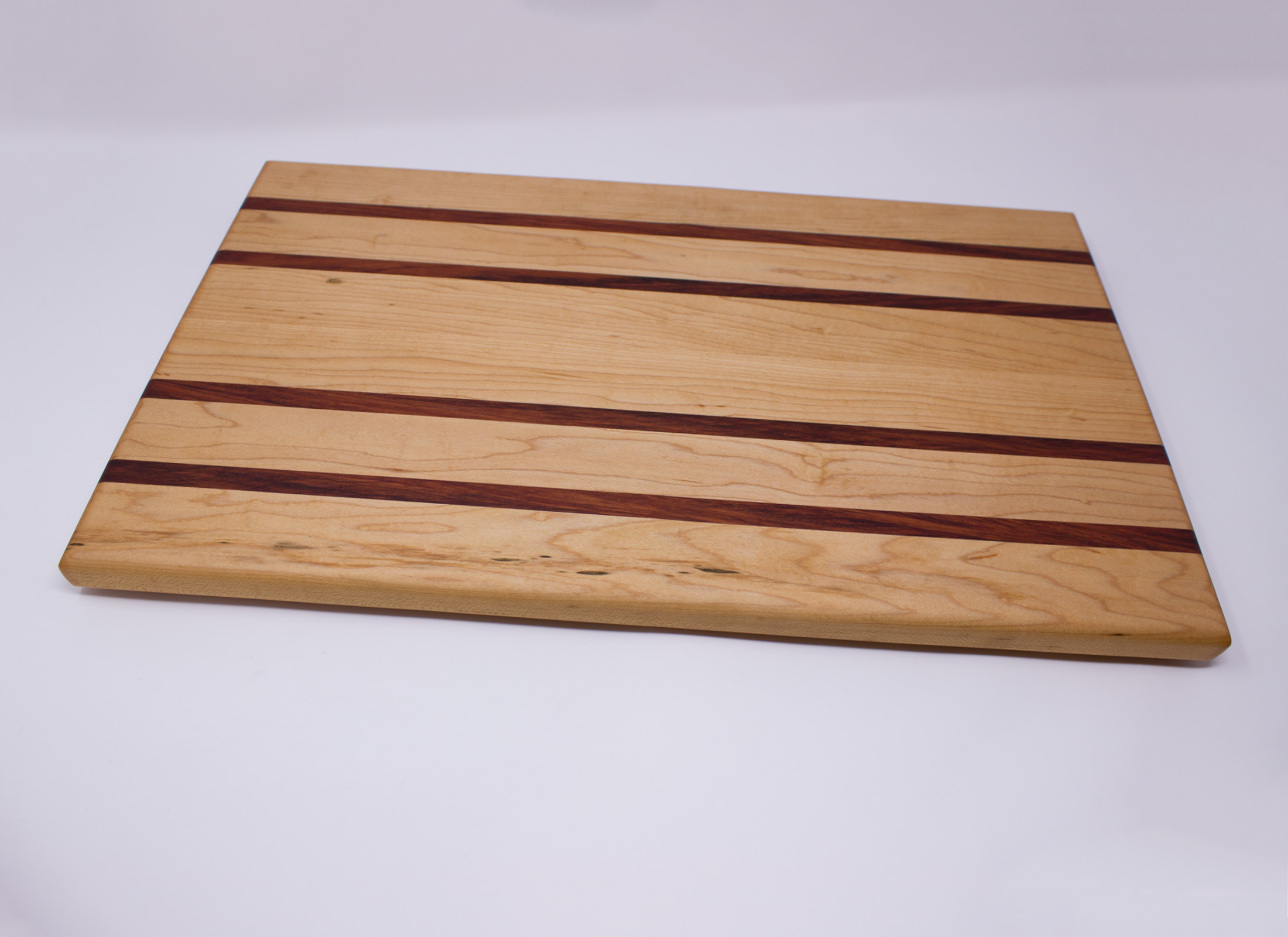 https://www.rockfordwoodcrafts.com/wp-content/uploads/Large-Maple-with-Four-Red-Stripes-Cutting-Board-Front-Angled.jpg