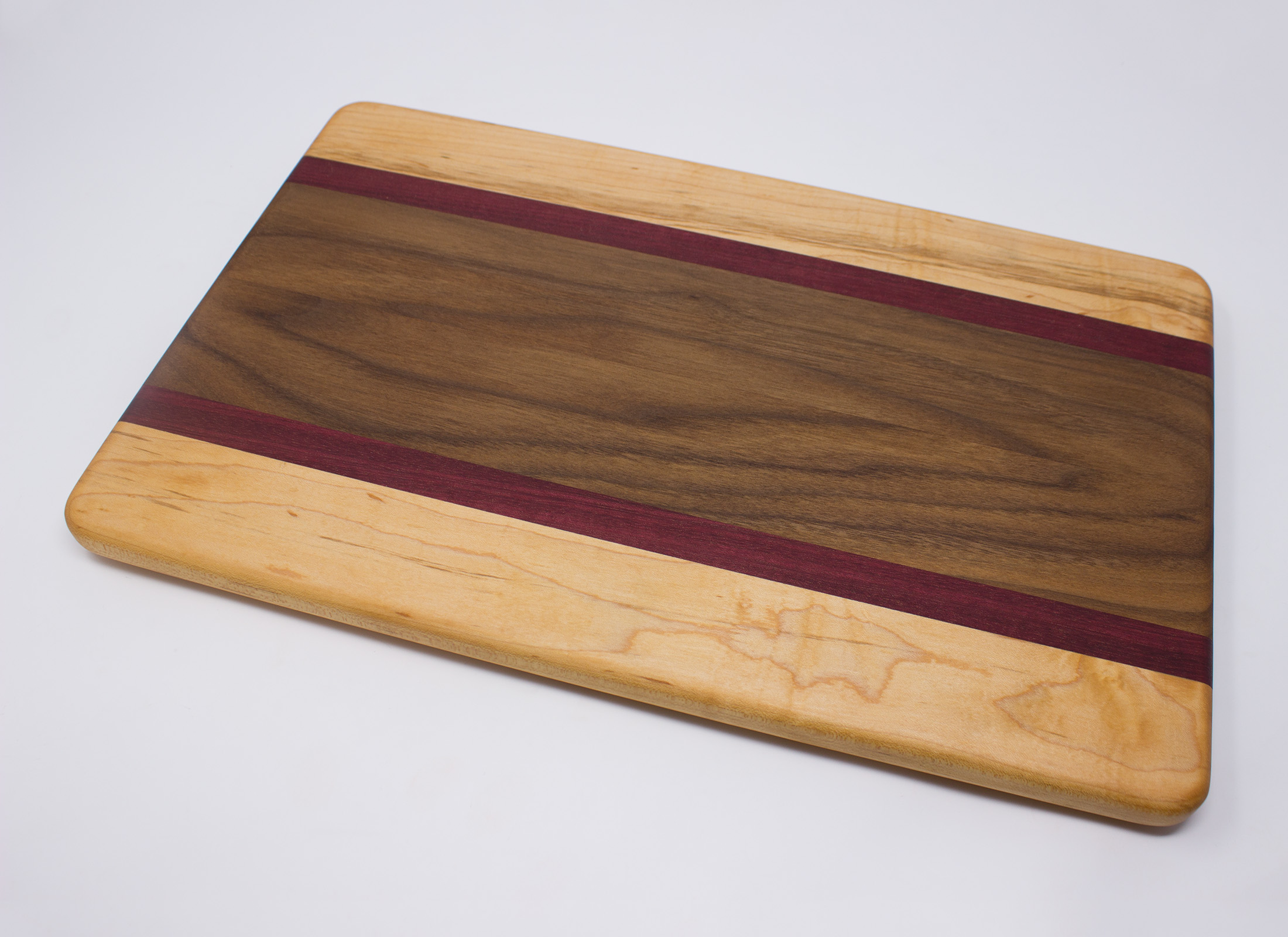 https://www.rockfordwoodcrafts.com/wp-content/uploads/Walnut-with-Purple-Stripes-and-Maple-Edges-Top-Angled.jpg
